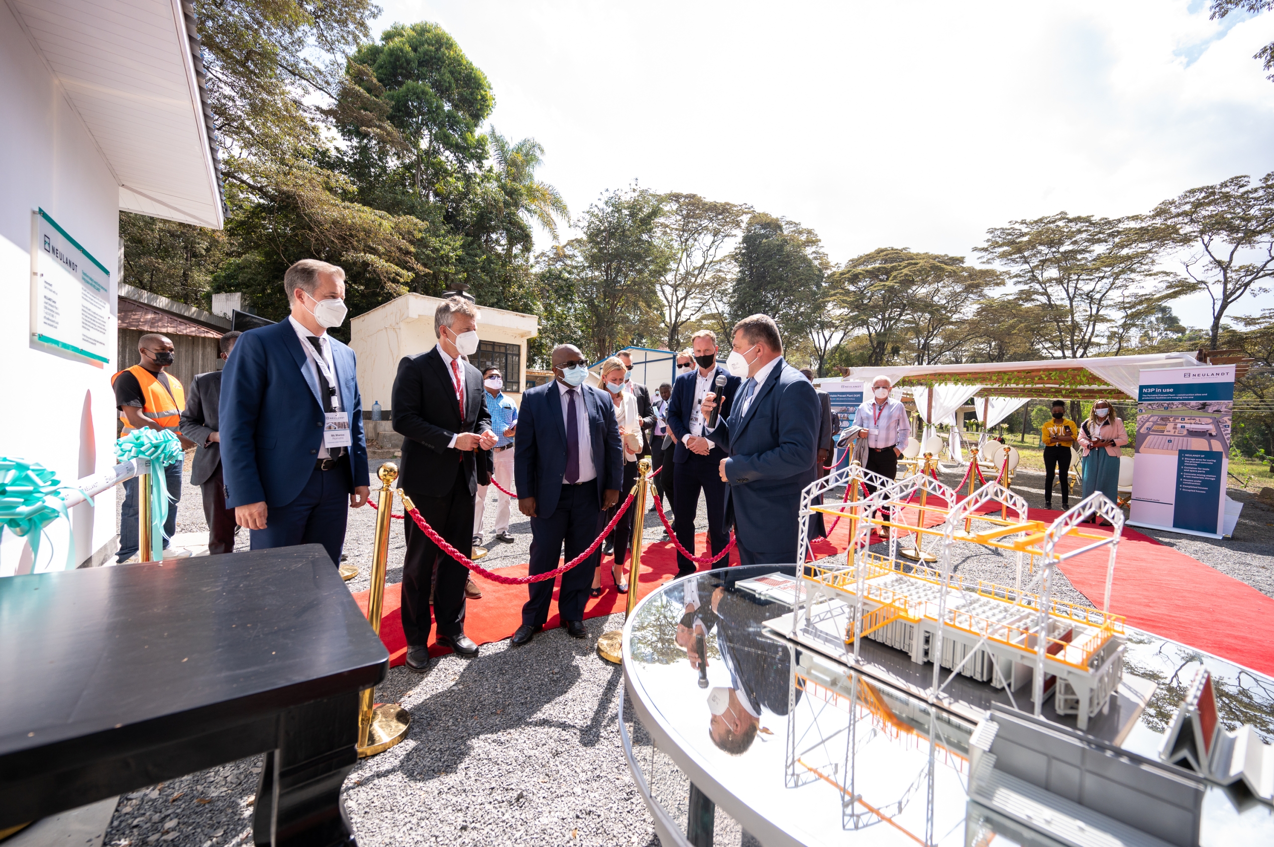 Businessman is giving a speech to a crowd of people in front of a model of the N3P precast plant and the show house at the NCA show ground in Kenia