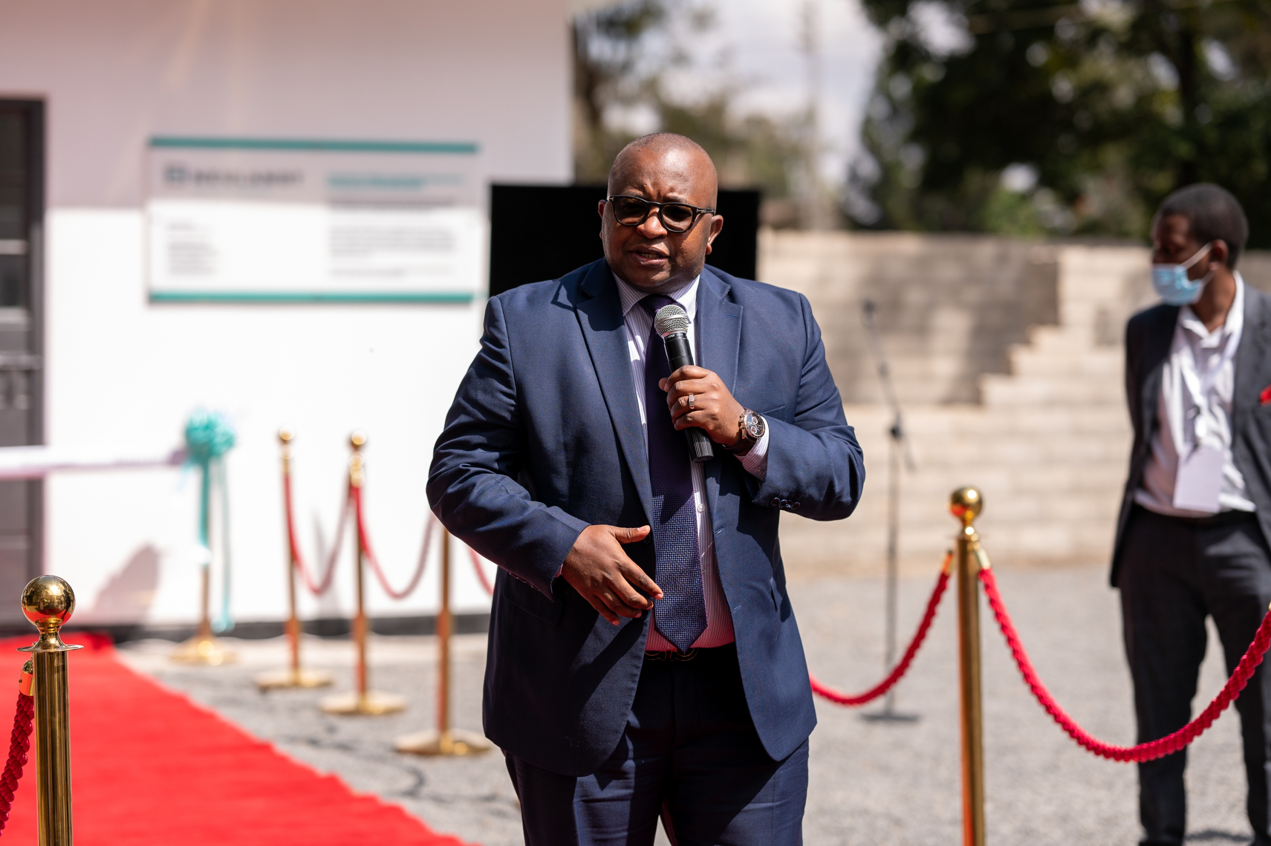 Business man is giving a speech while holding a microphone on the red carpet right in front of the show house at the NCA show ground in Kenia